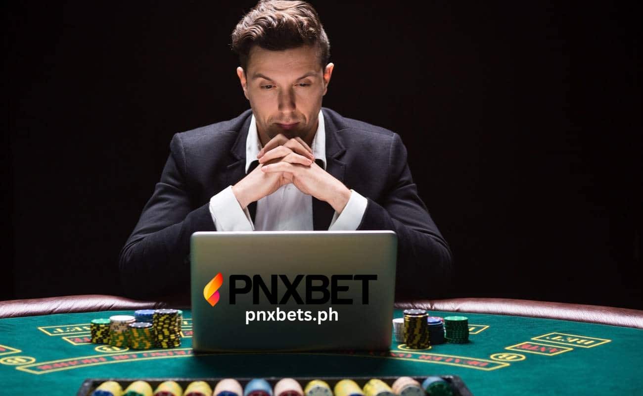 lalaking naka amerikano na ulitmo nakatapat sa kanyang laptop na meron mga chips sa kanyang tabi at mukang nagbabasa o nagiisip kung paano niya maipapasok ang kanyang pananaw upang maisapuso at maisip ang pag lalaro ng online casino, o gambling mind.